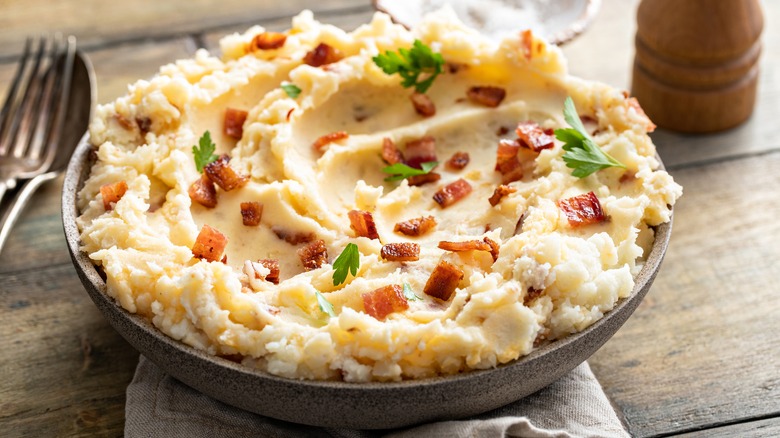 mashed potato with bacon bits and parsley in a bowl