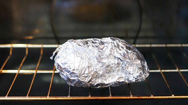 baked potato wrapped in foil in an oven