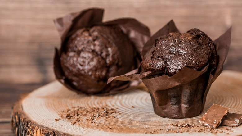 Large chocolate muffins on wooden board