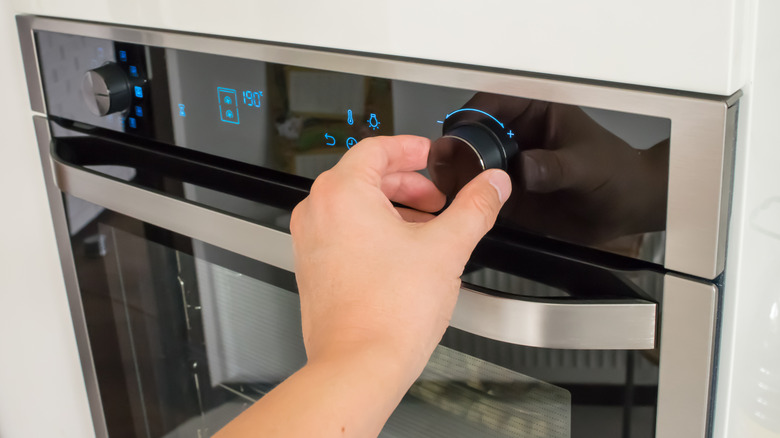 Hand adjusting oven temperature