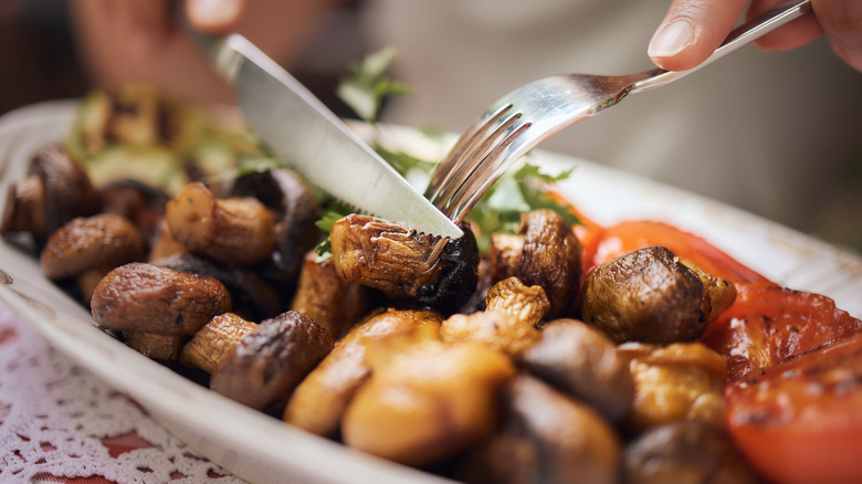 person eating roasted mushrooms