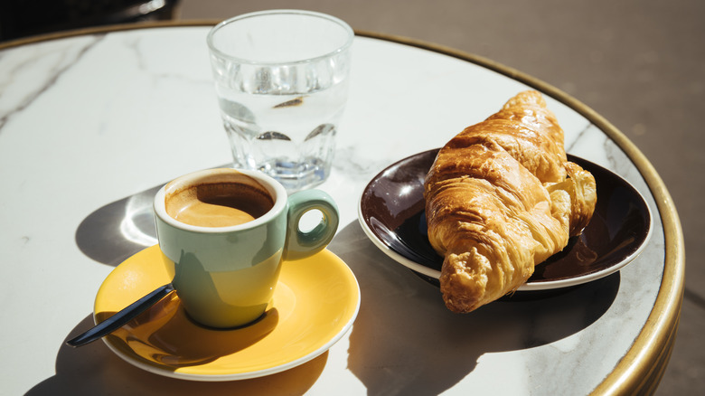 croissant with coffee and water