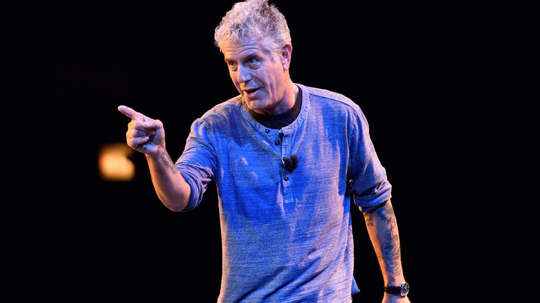 Anthony Bourdain on stage, pointing 