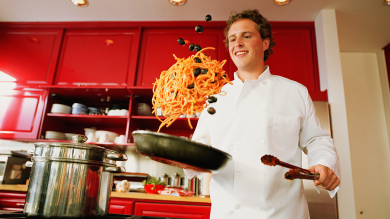 chef tossing pasta in a pan