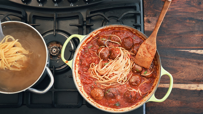 pasta cooking in a meatball sauce