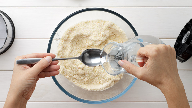 Pouring water into flour