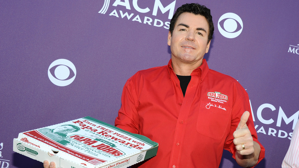 John Schnatter holding Papa John's Pizza