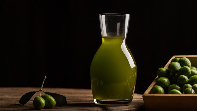 extra-virgin olive oil in carafe with olives