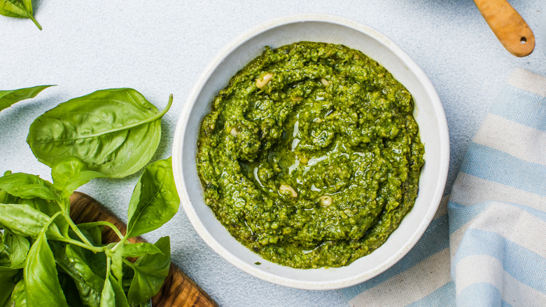 homemade pesto in white bowl with basil leaves