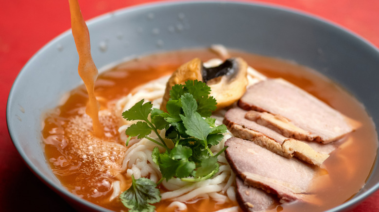 pouring broth into ramen