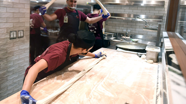 chefs stretching dough for ramen noodles