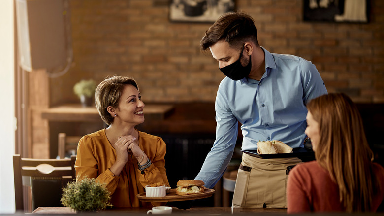 Waitstaff serving patrons food indoors