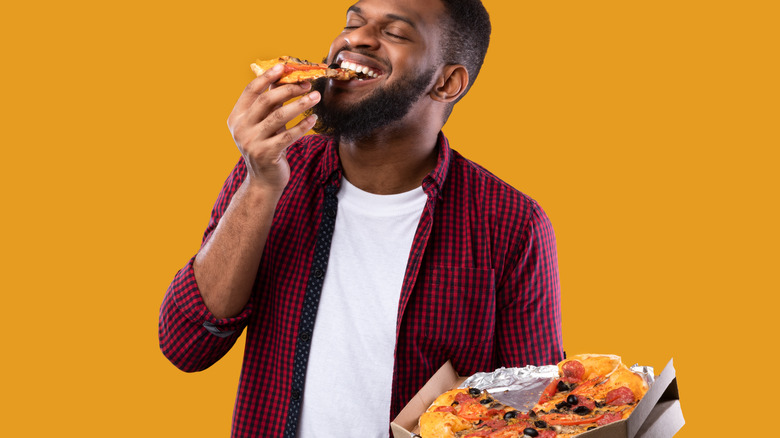 Happy man eating pizza 