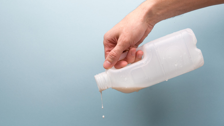 Man dumping spoiled milk