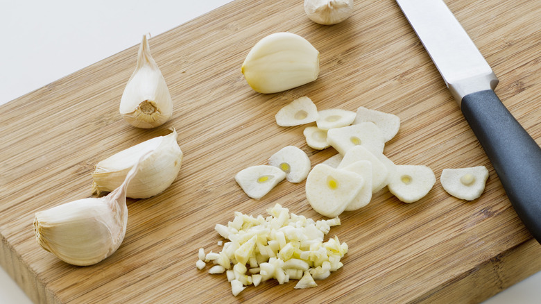 sliced and minced garlic on cutting board