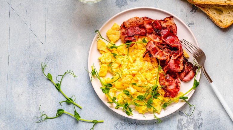 scrambled eggs on a plate with bacon