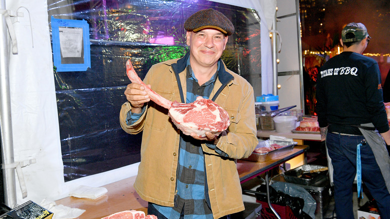 Michael Symon holding a steak