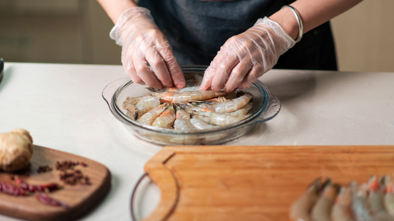 Person preparing raw shrimp