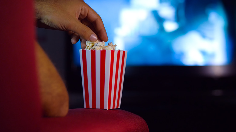 Grabbing popcorn in movie theater