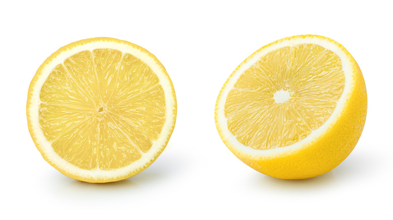 A lemon sliced in two, in different positions, over white background