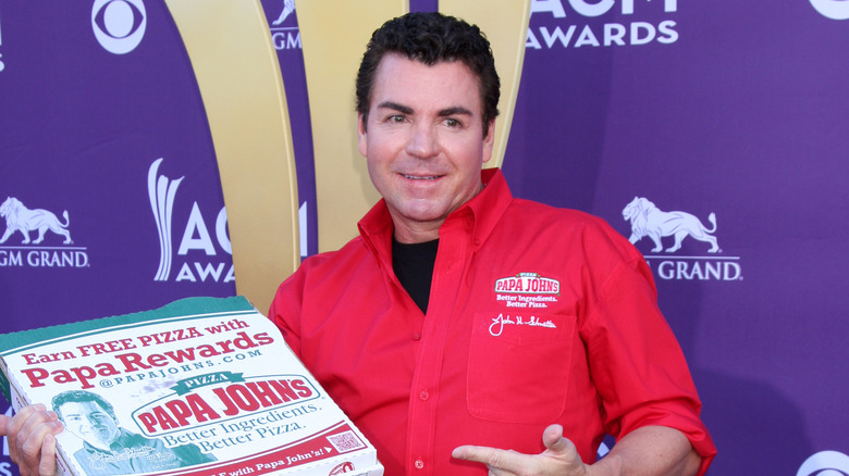 Papa John's founder John Schnatter holding pizza box