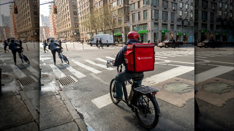 A DoorDash delivery person on a bike