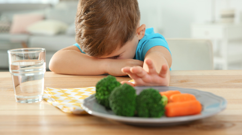 child rejecting vegetables