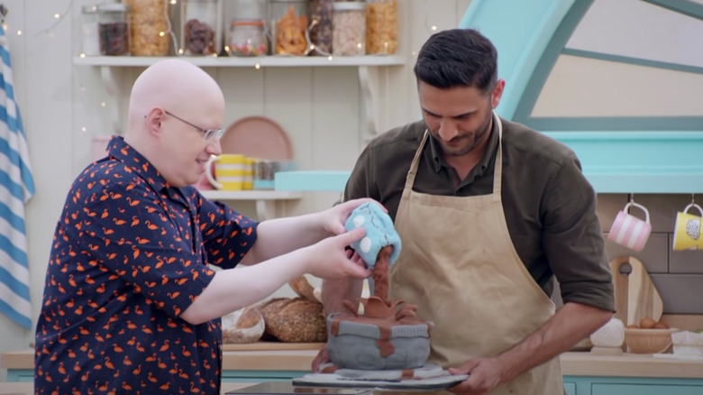 GGBO contestant holding gravity-defying cake