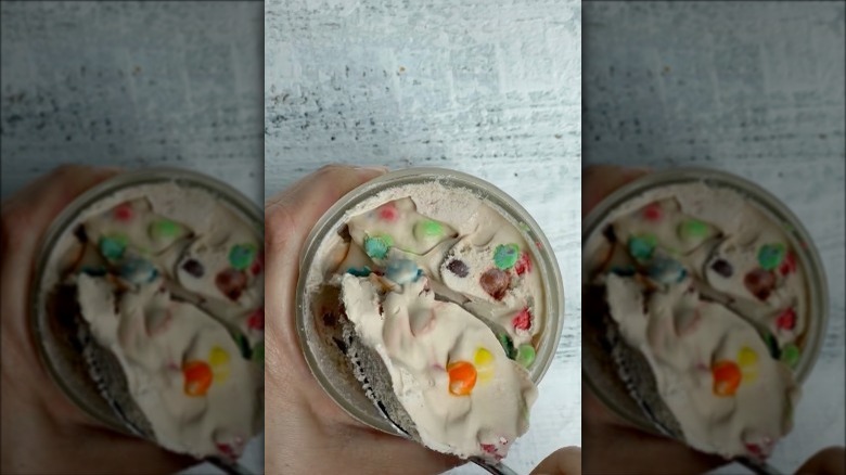 a person dipping a spoon into mason jar ice cream