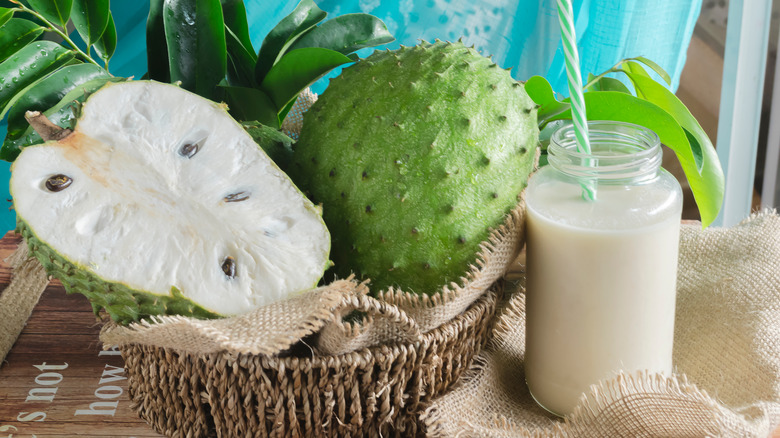 soursop fruit in a basket next to a glass of juice