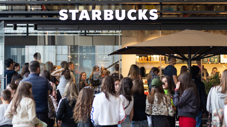 People standing in line outside of Starbucks