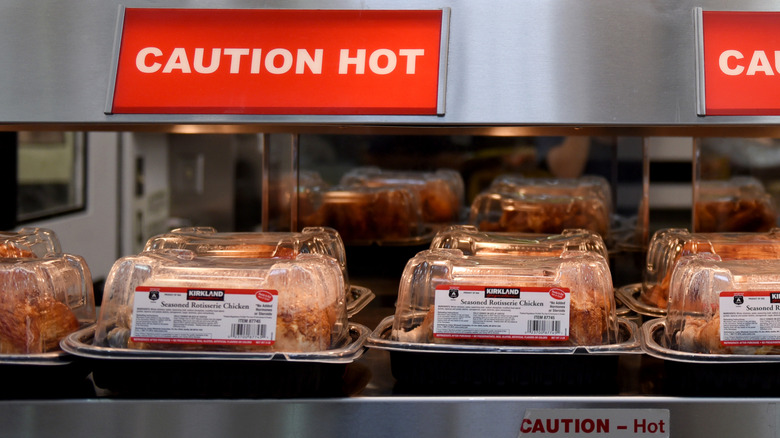 rotisserie chickens ready on a hot counter in a store