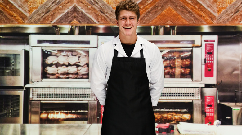 server behind a rotisserie chicken counter in a store