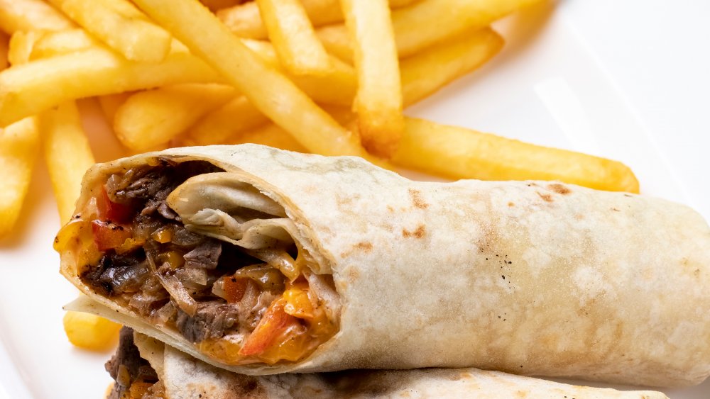 A burrito served with french fries 