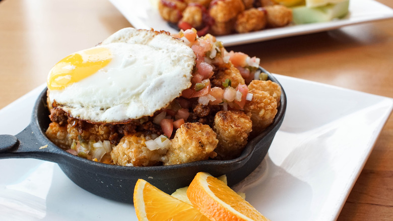 Tater Tots topped with a fried egg and salsa