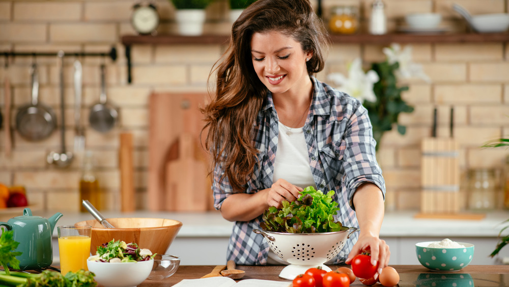 Woman making salad in home kitchen