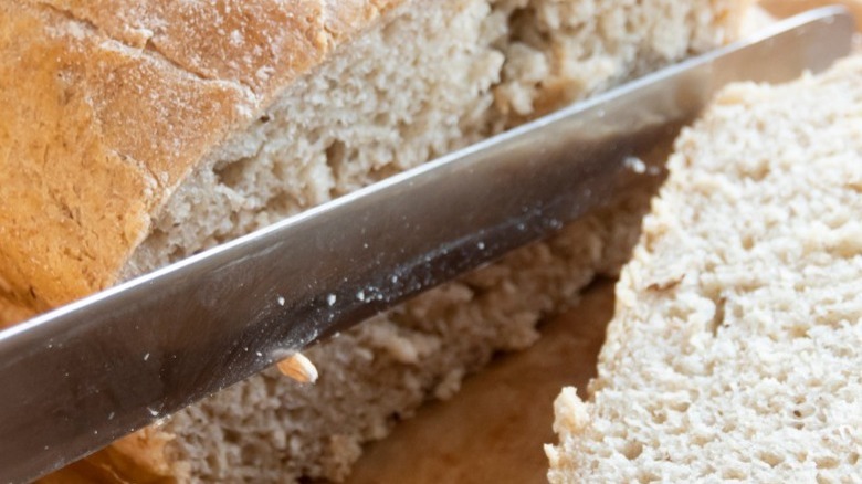 A knife slicing through a loaf of bread