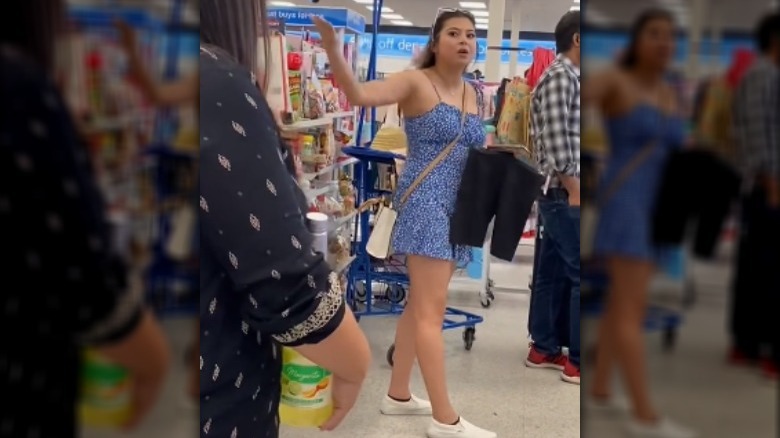 Woman in blue dress arguing with woman holding margarita