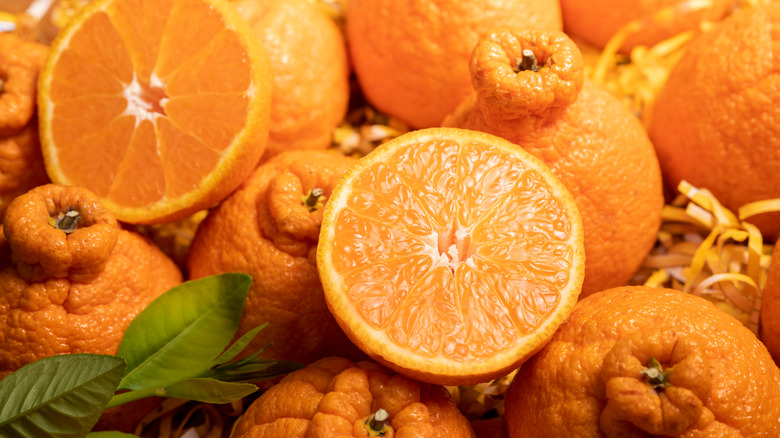 Whole and halved sumo oranges