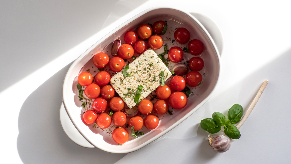 Trending viral Feta bake pasta recipe made of tomatoes, cheese, garlic and herbs in a casserole dish.