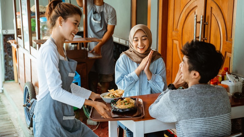 waitress serving two women in a restaurant