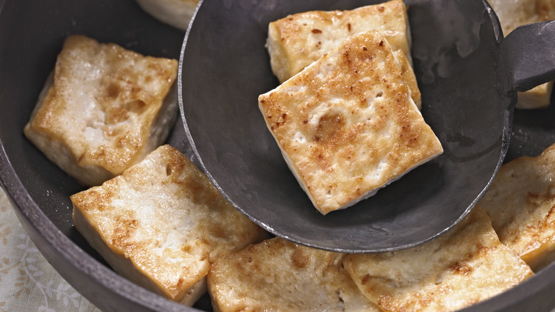 Tofu frying in a pan