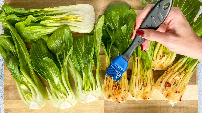 brushing spicy oil onto bok choy