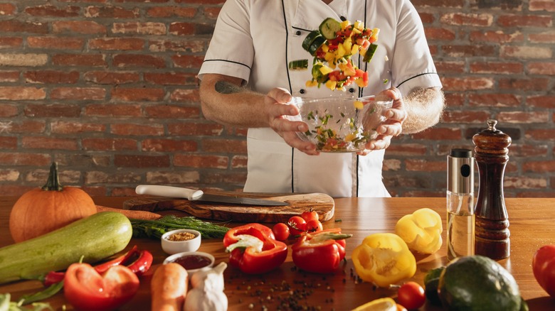 chef tossing a bowl of vegetables into the air