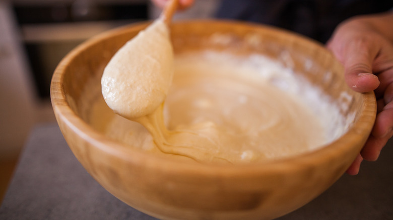 A bowl of waffle batter with a mixing spoon