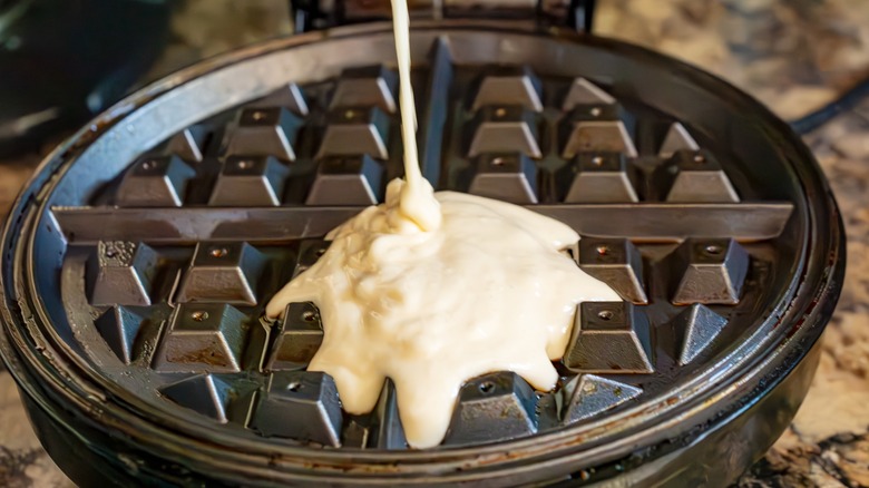 Batter being poured into a waffle iron