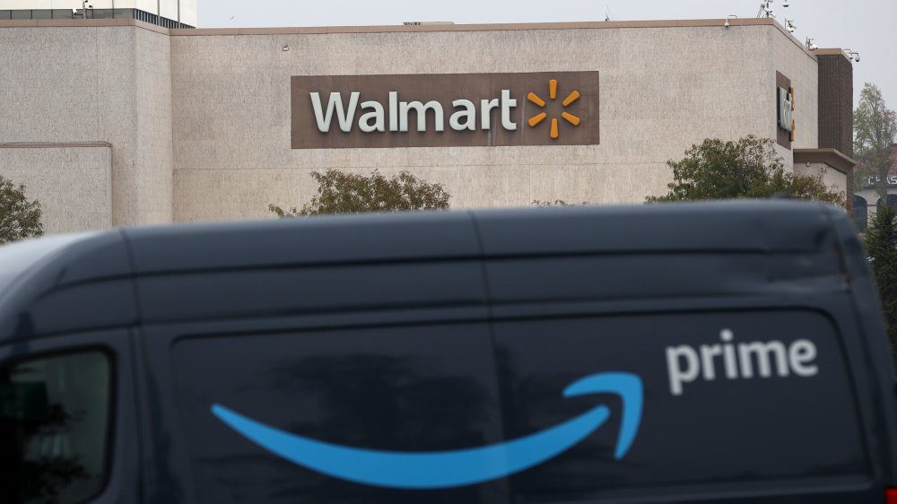 Amazon Prime delivery truck driving in front of a Walmart