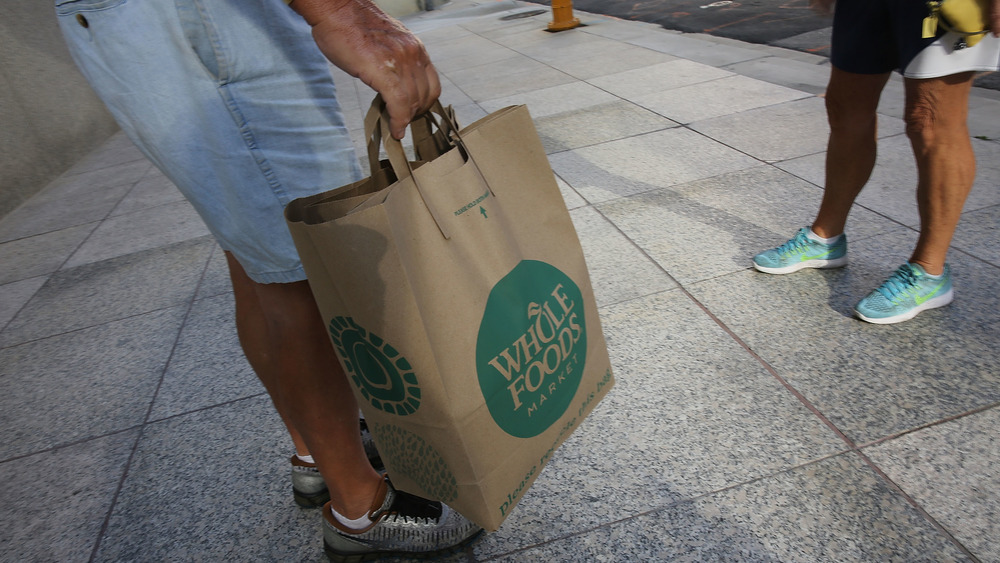 A shopper with a bag from Whole Foods