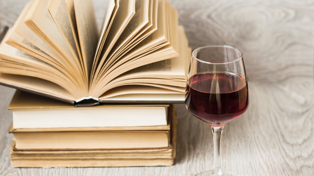 Glass of wine next to books
