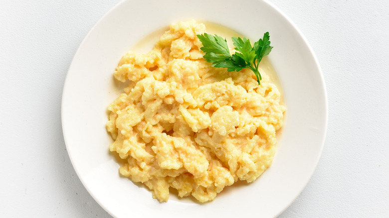 scrambled eggs with garnish on white plate